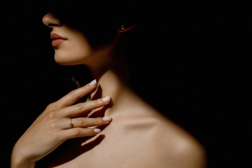 Girl in the shadows with her hand on her collarbone | Skylum Blog