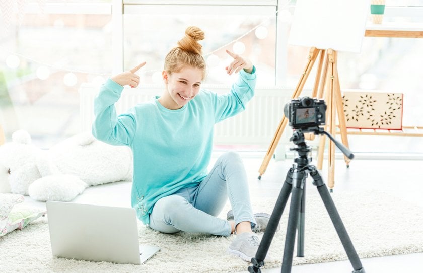 A girl poses for a camera on a tripod | Skylum Blog