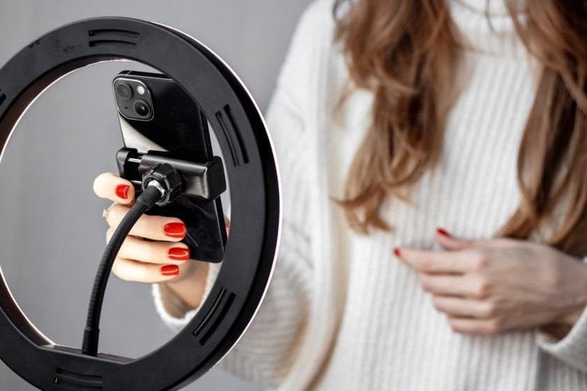 A girl adjusts a phone on a tripod | Skylum Blog