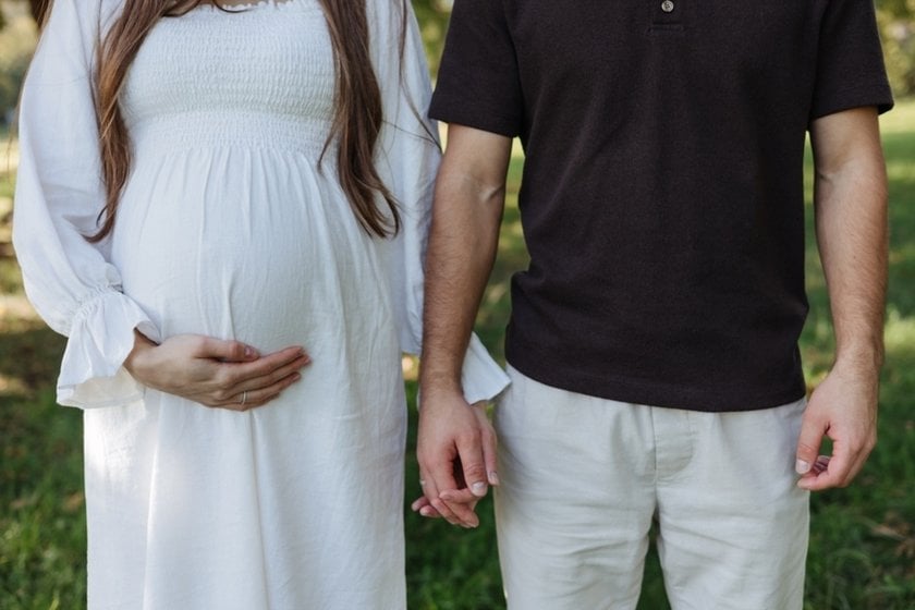 Husband and pregnant wife holding hands | Skylum Blog