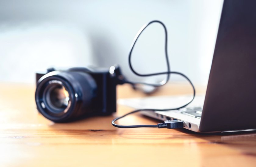 A camera connected to a laptop | Skylum Blog