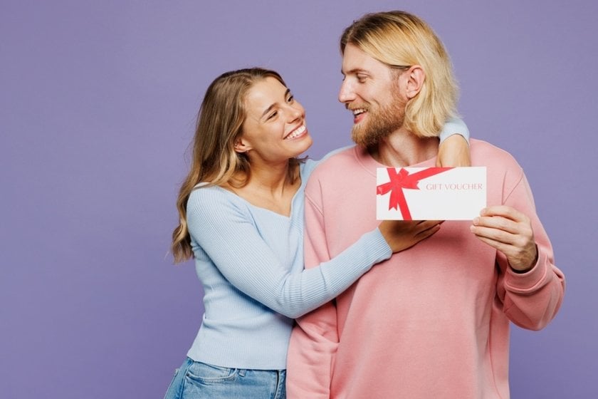 Smiling couple holding a small gift box together | Skylum Blog