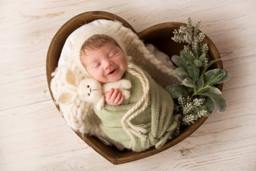 Photo of a sleeping newborn with a smile | Aperty Blog