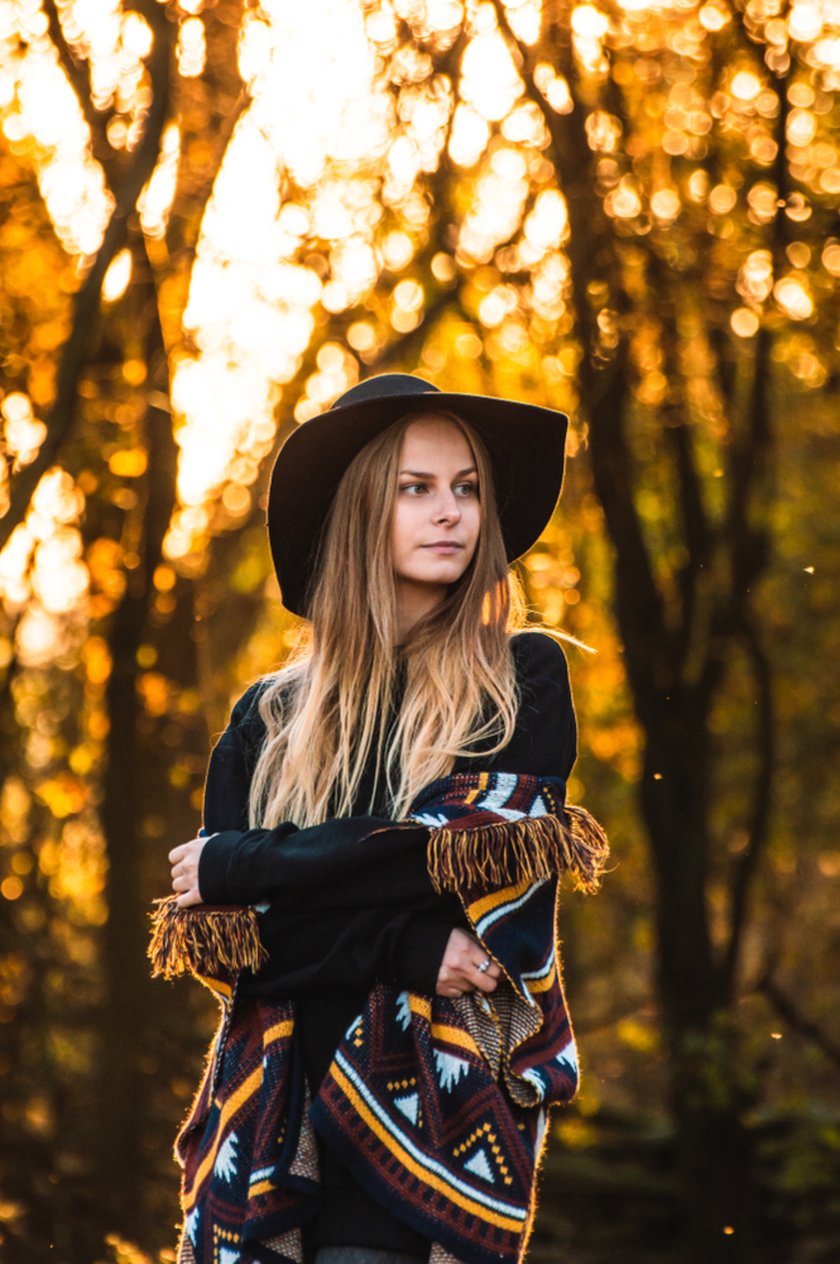 A girl in a hat looks into the distance in autumn | Skylum Blog