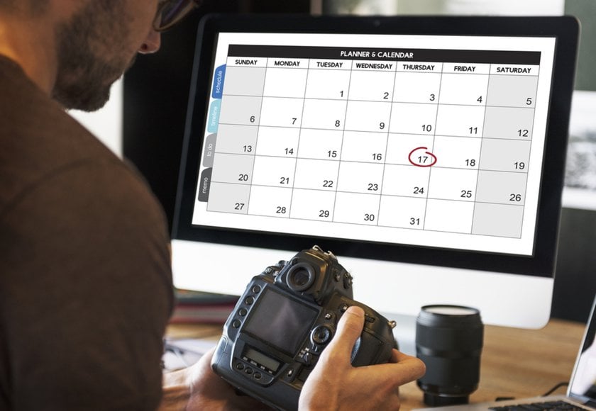 A photographer with a camera and a schedule on his computer | Aperty Blog