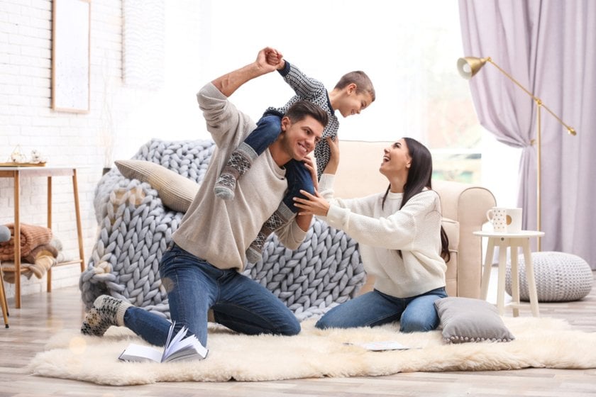Parents play with their son in the house in winter | Aperty Blog