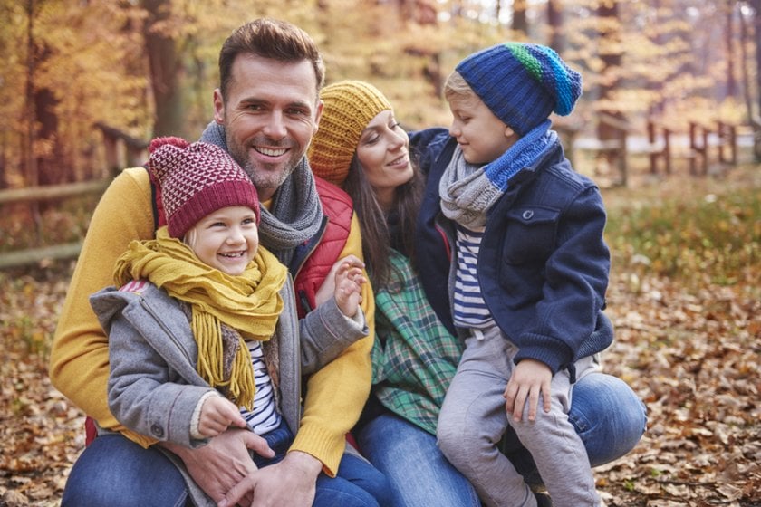 A photo of a family in autumn wearing warm clothes in a park | Aperty Blog