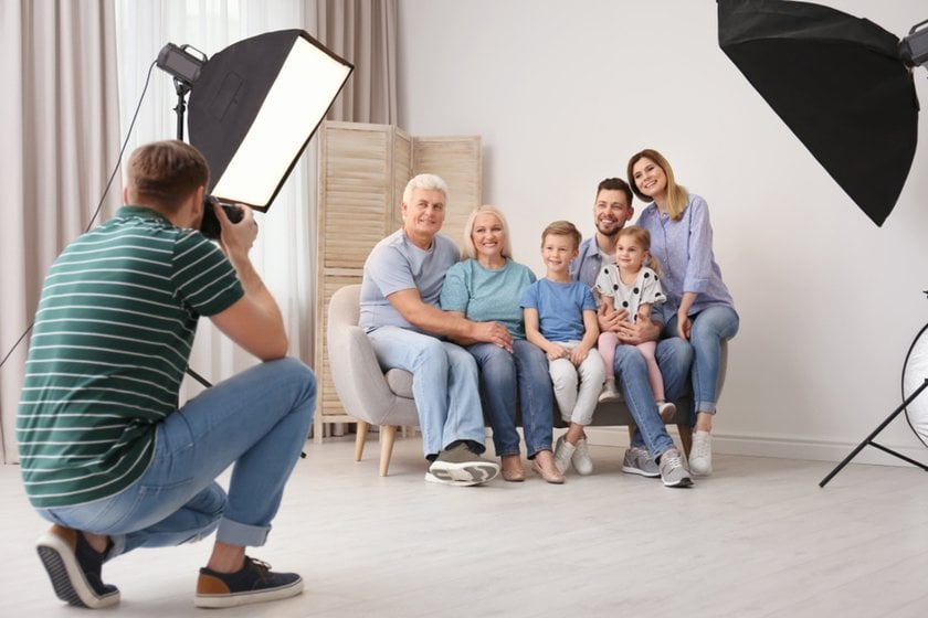 A photographer takes a photo of a family in a studio | Aperty Blog