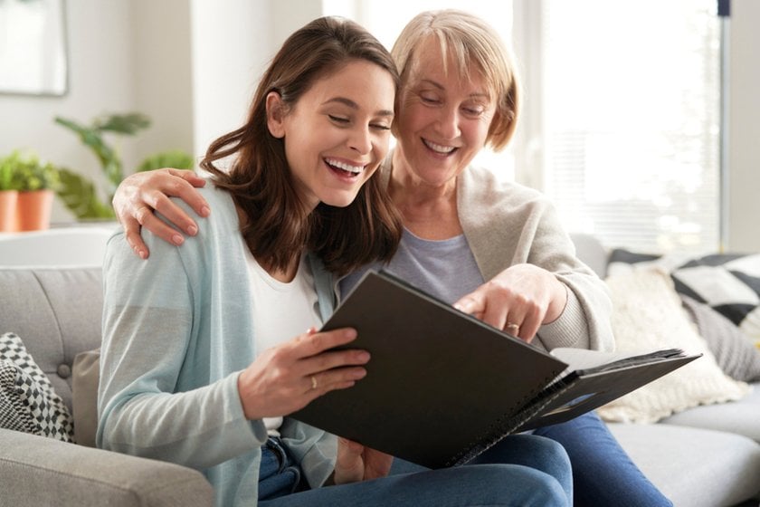 A mother and daughter are looking at a photo album | Skylum Blog