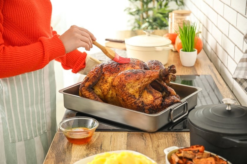 A woman brushes sauce on a turkey | Skylum Blog