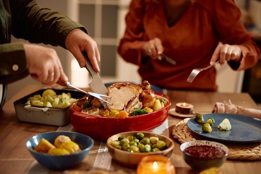 People cutting meat at dinner - close-up photo | Skylum Blog