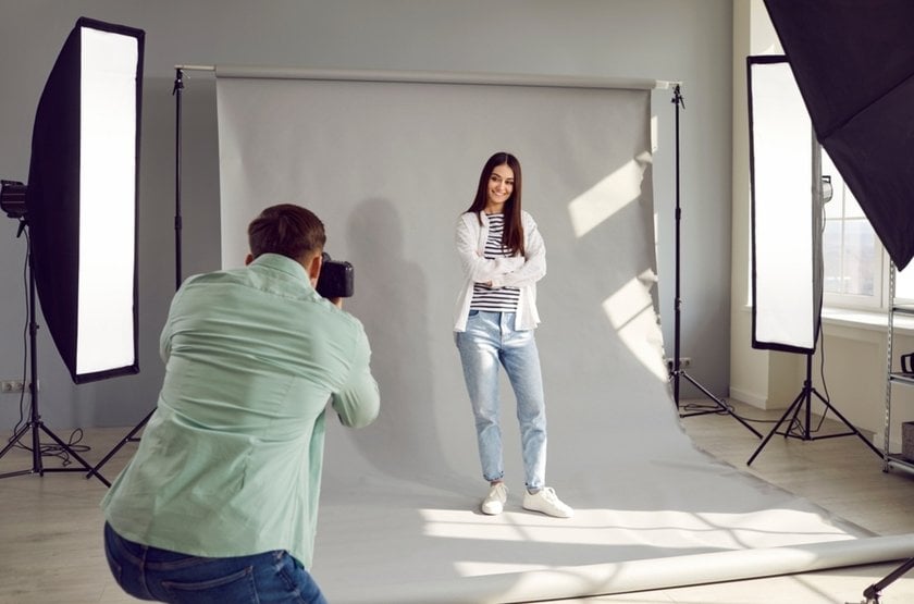 A photographer takes a photo of a model in a studio | Aperty Blog