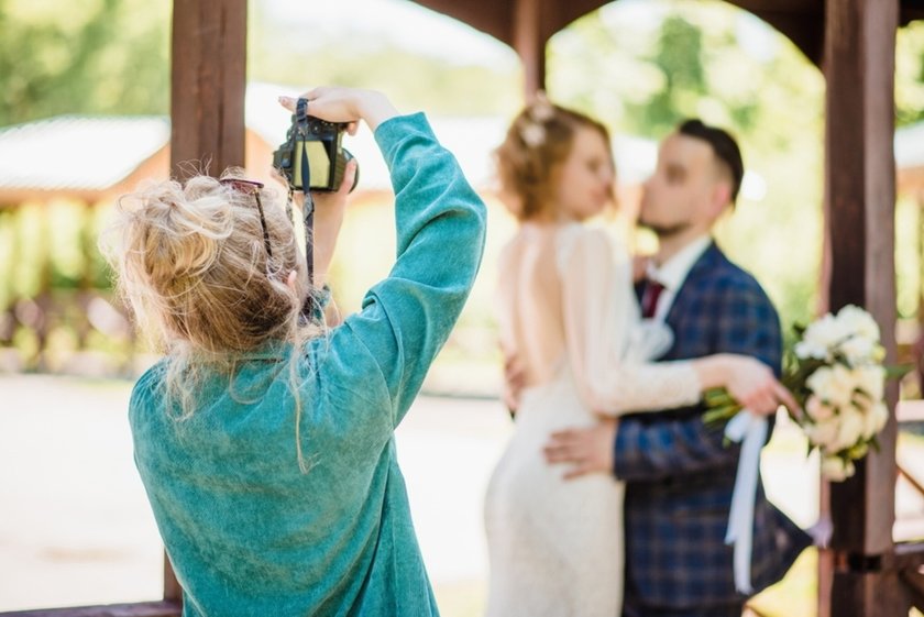 A photographer takes a photo of the newlyweds | Aperty Blog