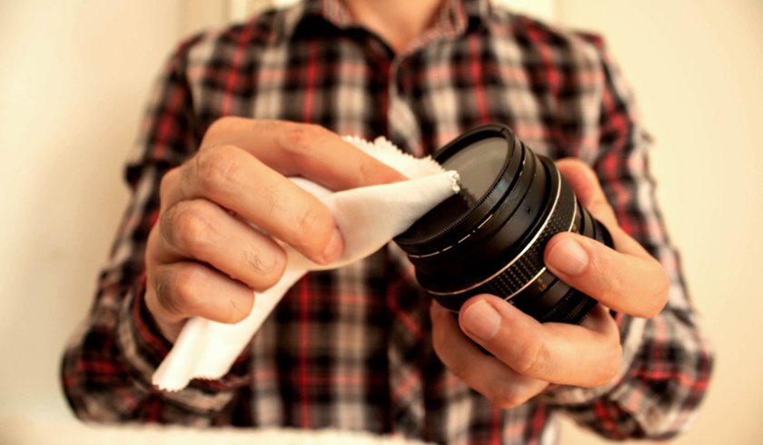A photographer wipes the lens with a special cloth | Aperty Blog