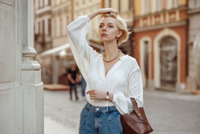 A girl fixes her hair on the street | Skylum Blog