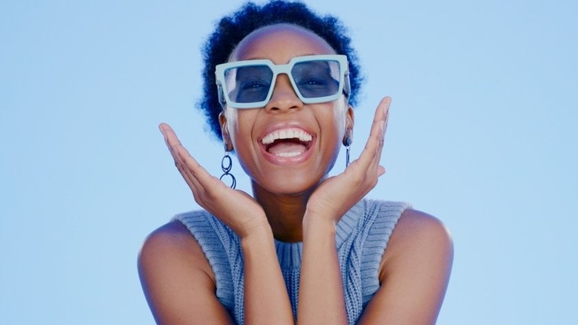 Laughing girl holding hands around face | Skylum Blog