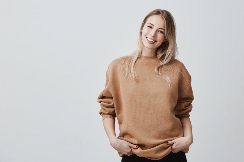 The girl holds her hand in her pockets with her thumbs out | Skylum Blog