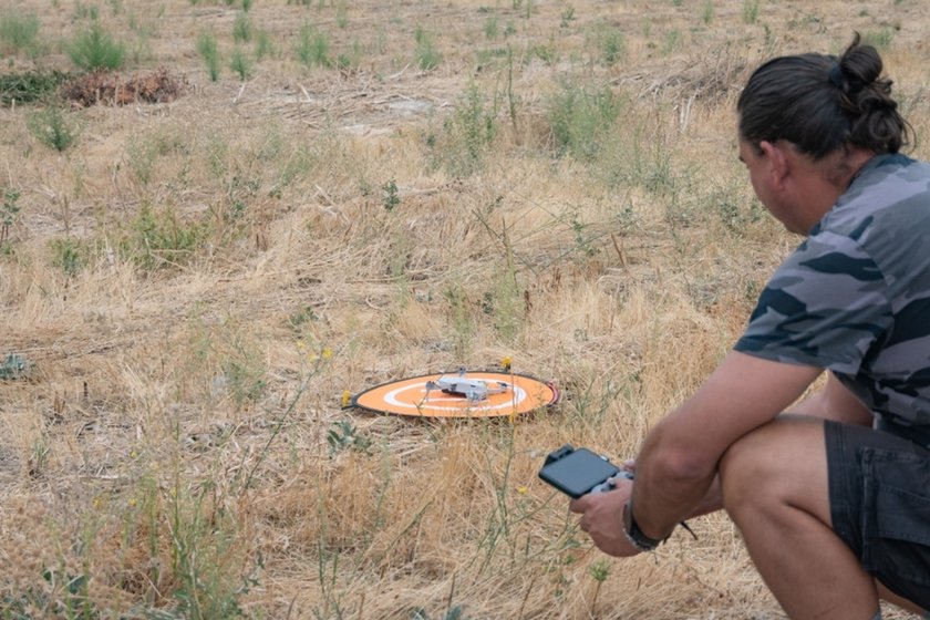 A man launches a drone from a landing pad | Skylum Blog