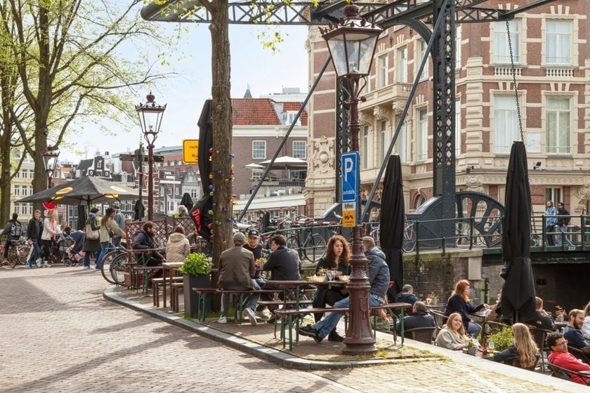 People are sitting at tables on the street | Skylum Blog