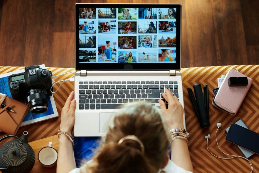 Girl Looking at Her Photo Portfolio on a Laptop | Skylum Blog