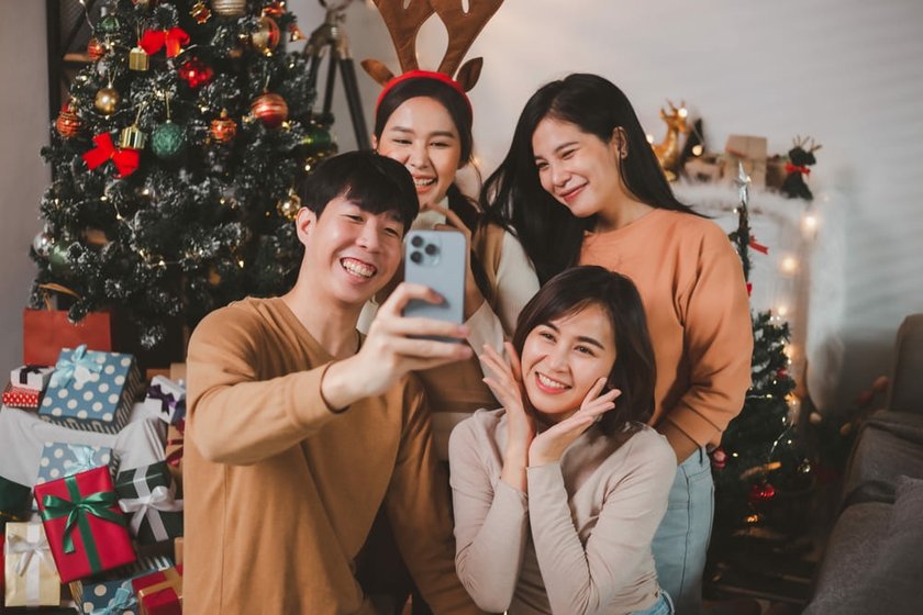 Group of Friends Taking an iPhone Selfie in Front of the Christmas Tree | Skylum Blog