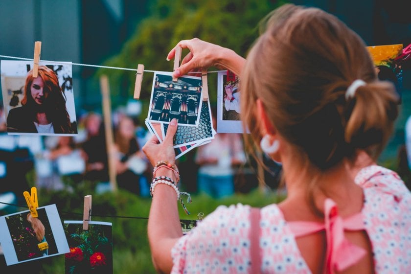 The girl hangs up photos| Skylum Blog