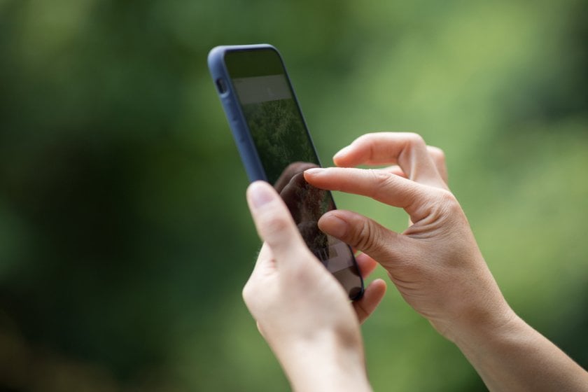 Girl zooms in on photo on smartphone | Skylum Blog
