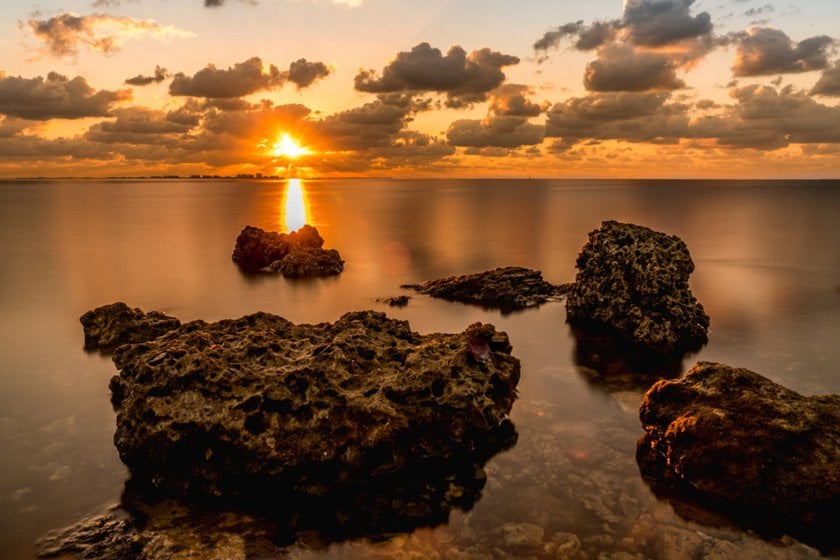 Photo of water and rocks in the foreground at sunset | Skylum Blog