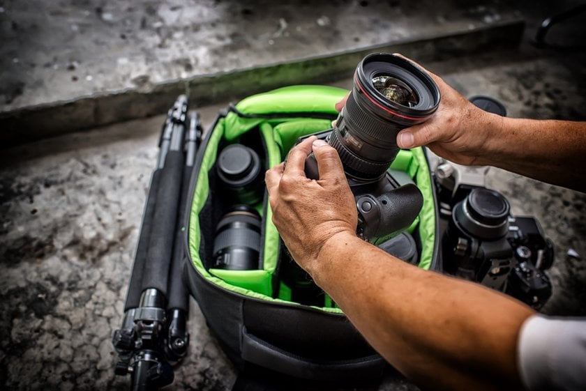 A photographer packs his camera into his bag | Skylum Blog