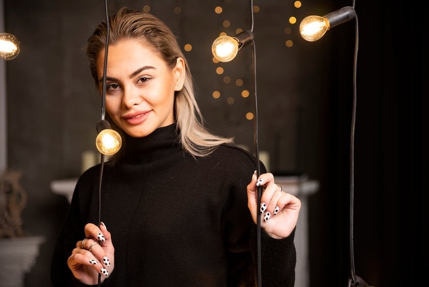 A girl in a black sweater near garlands | Skylum Blog