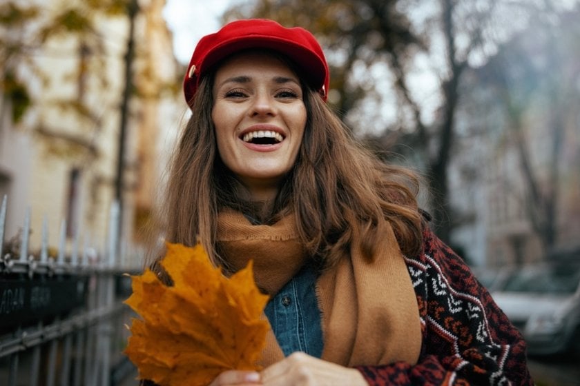 A girl in a hat and autumn leaves in her hands | Skylum Blog