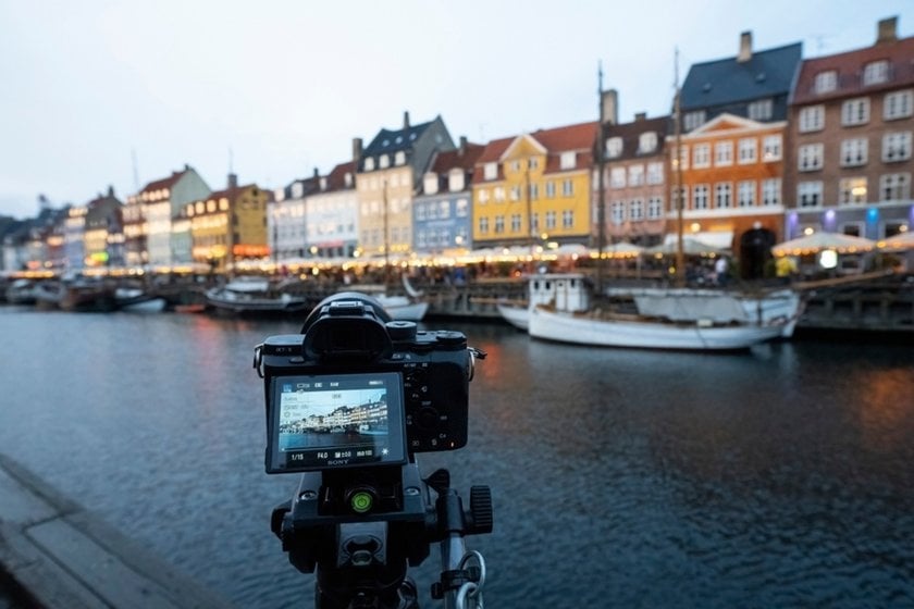 A camera on a tripod takes a photo of the city's architecture | Skylum Blog