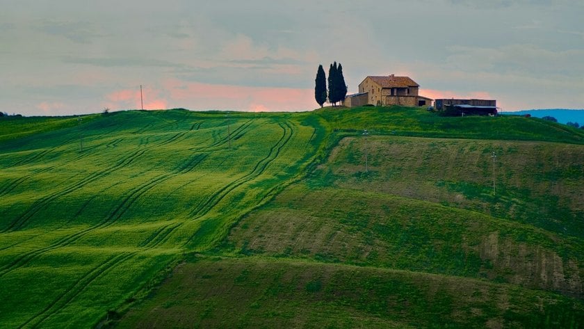 Green field with a building | Skylum Blog