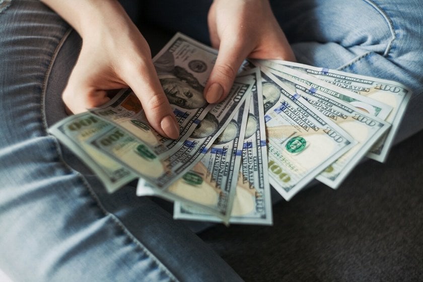 A girl holds money in her hands | Skylum Blog