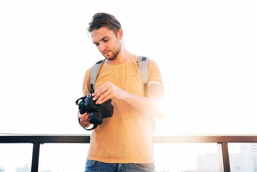 A photographer adjusts his camera | Skylum Blog