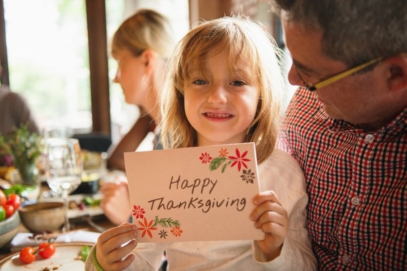 A girl holds a Thanksgiving card in her hands | Skylum Blog