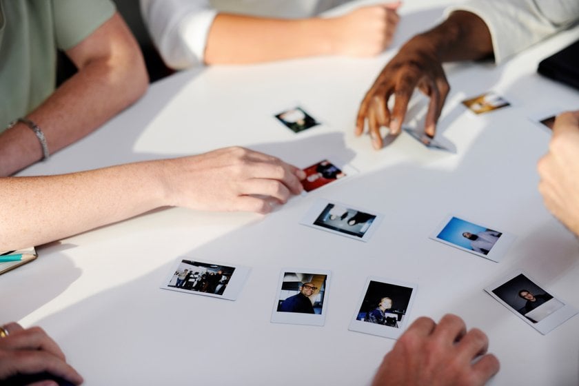 People look at small photographs | Skylum Blog