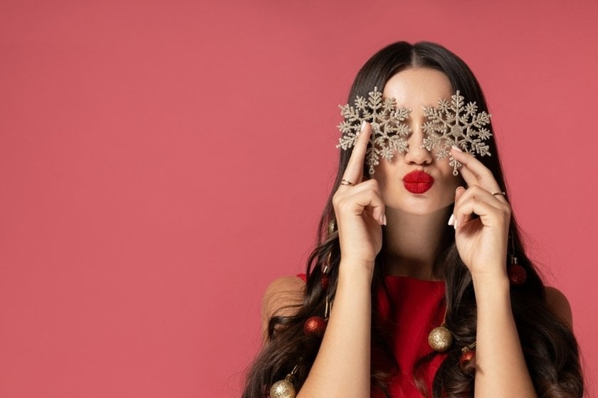 A girl with snowflakes in her hand on a pink background | Skylum Blog