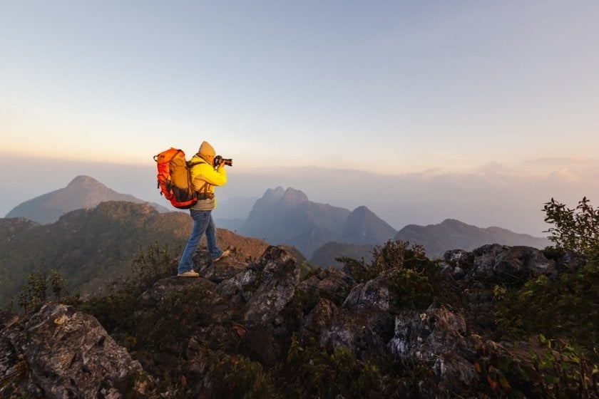 A photographer with a backpack takes photos of nature | Skylum Blog