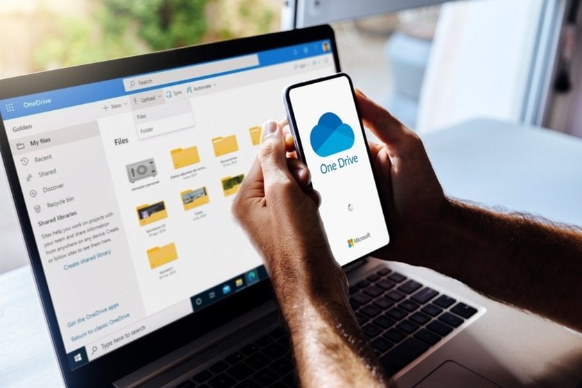 A man with a phone in his hands in front of a laptop | Skylum How-to