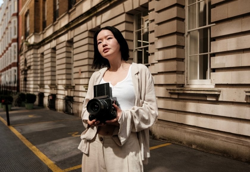 Photo of a girl with a camera on the street | Skylum Blog