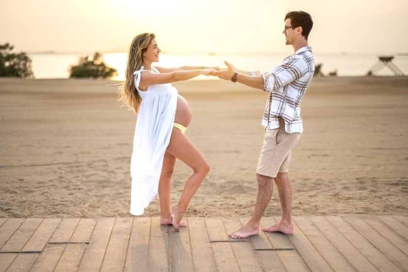 A man and his pregnant wife dance on the beach | Skylum Blog