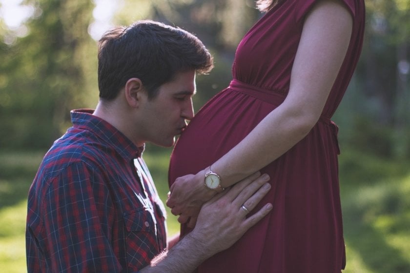 A man kisses his pregnant wife's belly | Skylum Blog