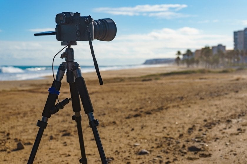 A camera on a tripod on the beach | Skylum Blog