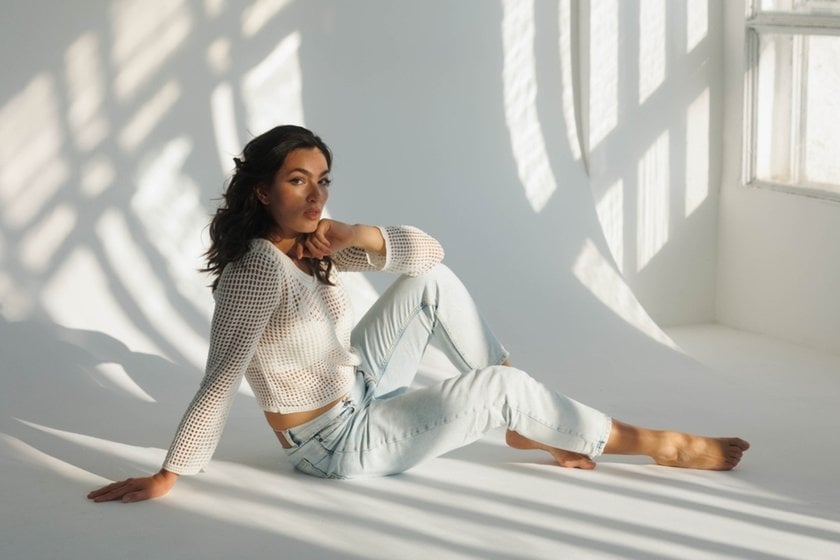Photo of a girl on the floor in a bright room opposite a window | Skylum Blog