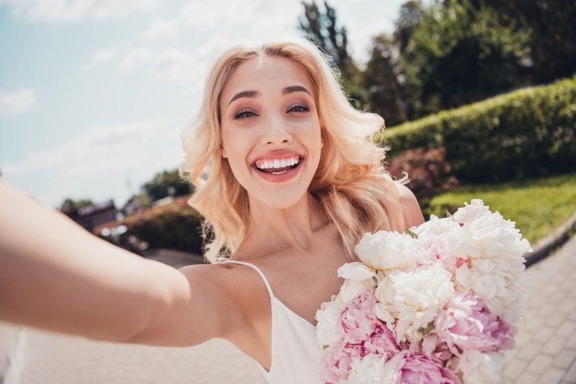A girl with a bouquet takes a selfie | Skylum Blog