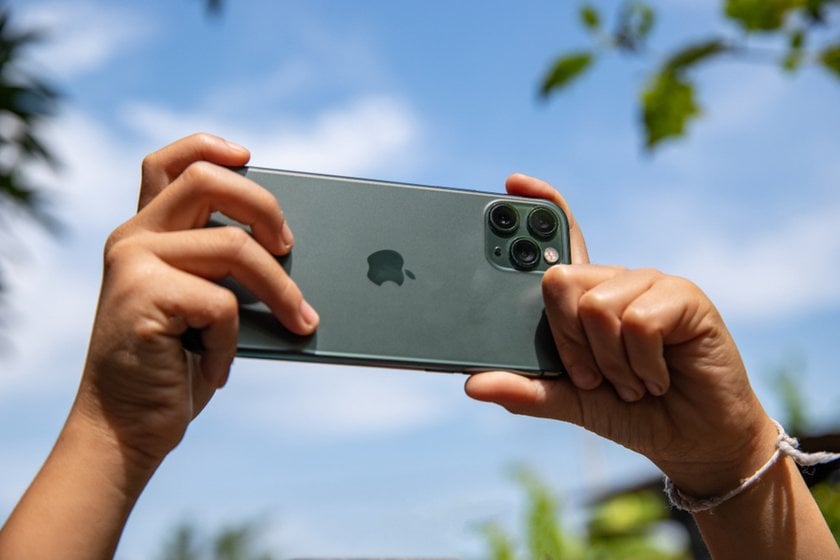 A man takes a photo on an iPhone | Skylum Blog