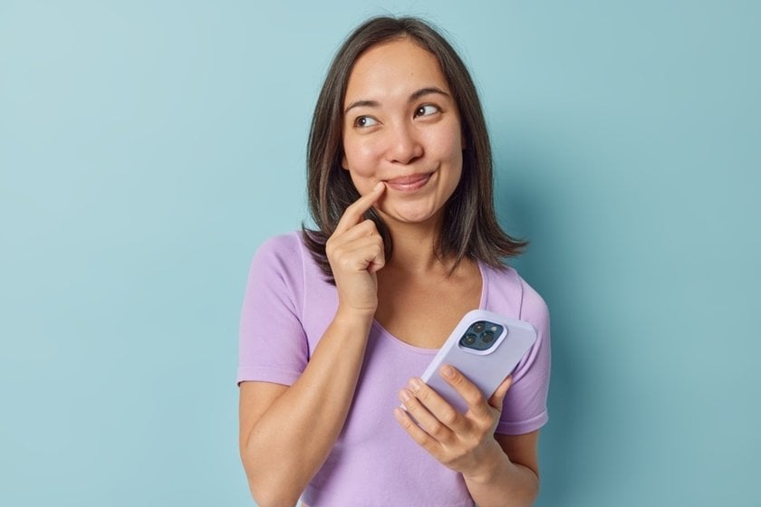 Woman holding smartphone looking confused while troubleshooting | Skylum How-to