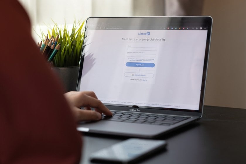 Person working on a laptop at a wooden desk | Skylum How-to