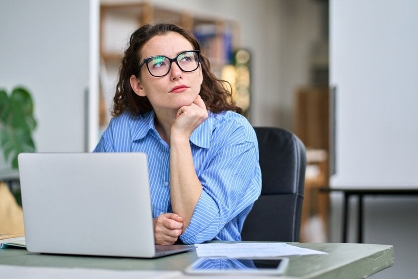 A girl thinks behind a laptop screen | Skylum Blog